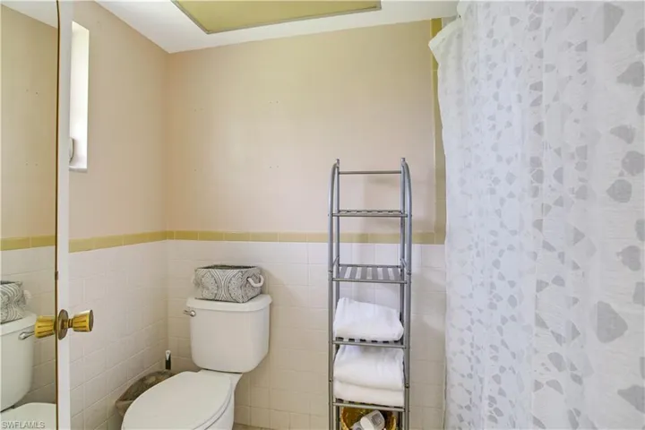 Bathroom with tile walls and toilet