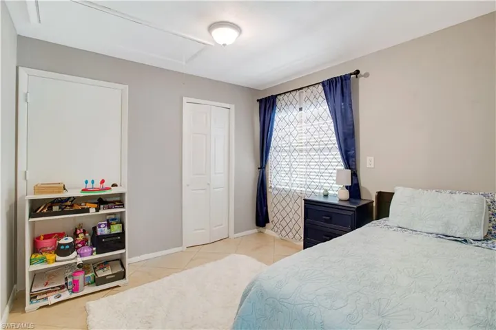Bedroom with a closet and light tile flooring