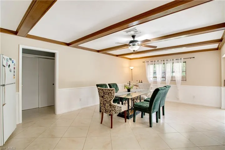 Tiled dining area with beam ceiling and ceiling fan