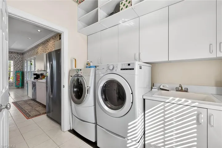 Laundry room with separate washer and dryer, cabinet space, light tile patterned floors, recessed lighting, and crown molding