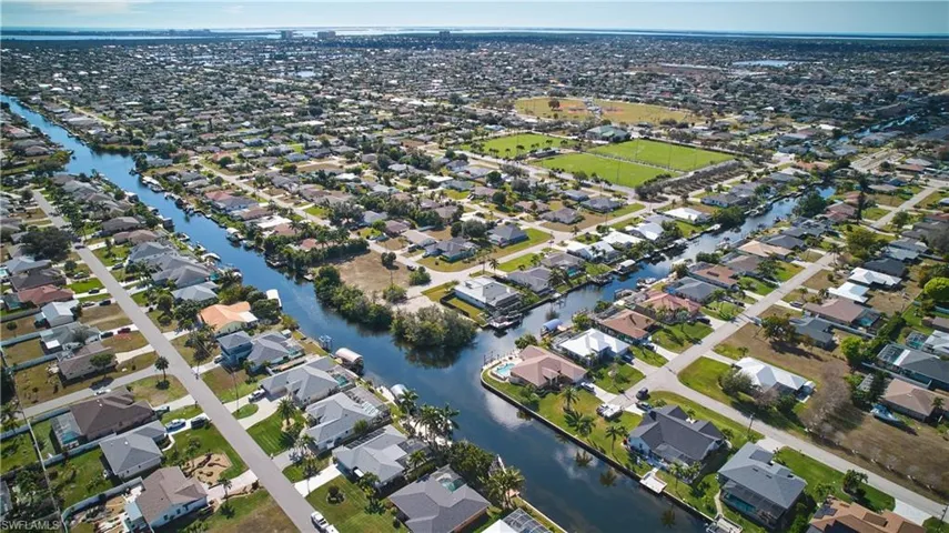 Aerial view of property's location with a nearby body of water and nearby suburban area