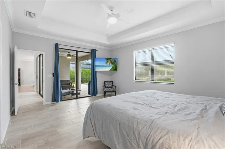 Large room with feature wall, tray ceiling and access to lanai