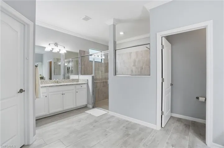 Walk in tiled shower, two separate vanities and sinks, two walk in closets