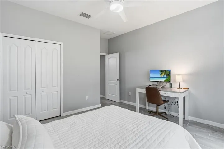 Spacious room featuring light gray walls and contemporary wood-finish flooring