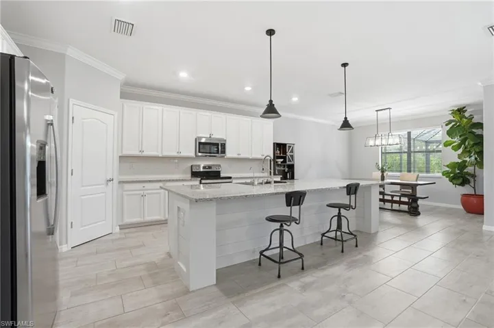 Kitchen with huge island, granite counters and stainless steel appliances