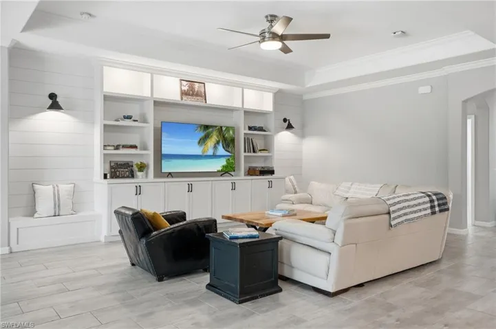 Built-in entertainment center with open shelving and lower cabinetry, recessed lighting, and wall-mounted sconces