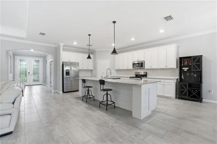 Kitchen with huge island, granite counters and stainless steel appliances