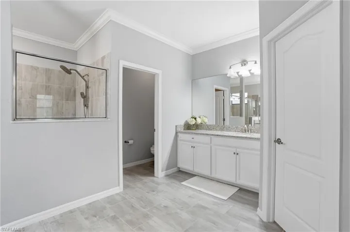 Walk in tiled shower, two separate vanities and sinks, two walk in closets