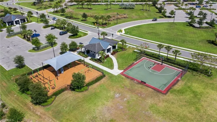 Community amenities featuring a shaded playground with wood chip surfacing, a full basketball court, and a clubhouse building