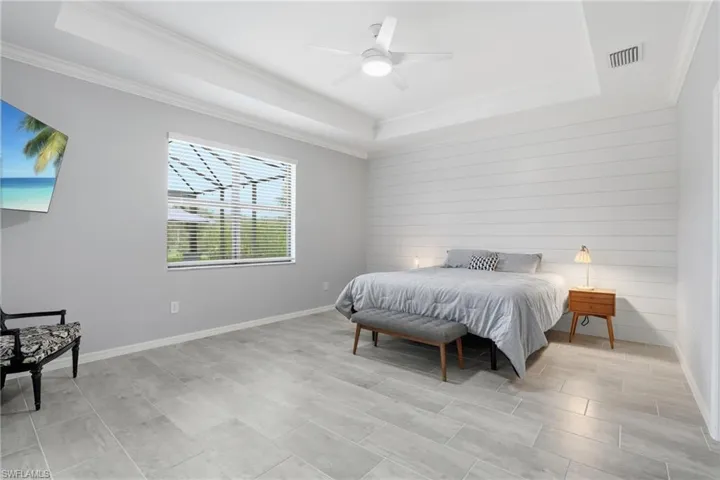 Large room with feature wall, tray ceiling and access to lanai