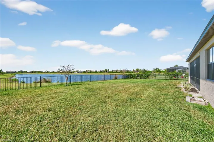 Fenced backyard featuring a water view and a sunroom