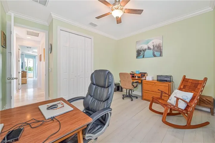 Office space featuring crown molding, ceiling fan, and light hardwood / wood-style floors