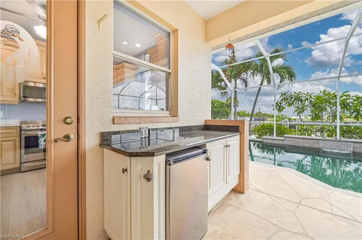Kitchen with light tile patterned flooring and stove