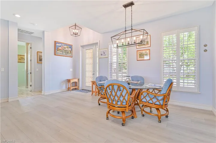 Dining space with light hardwood / wood-style flooring and an inviting chandelier