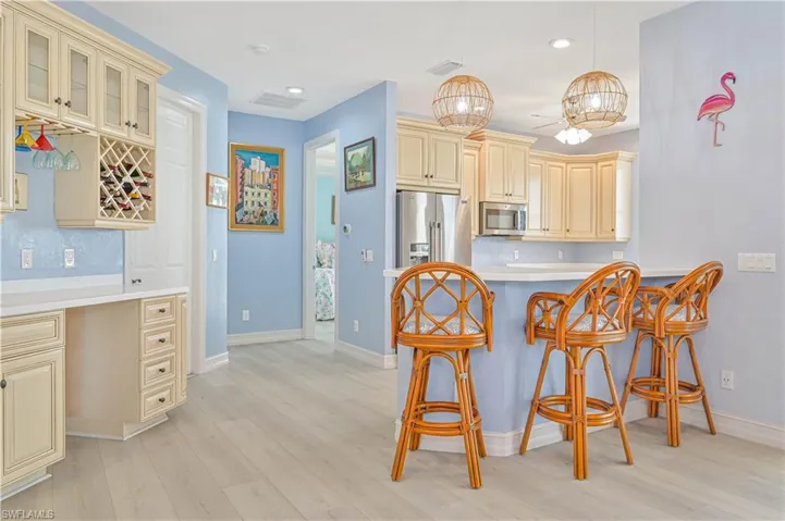 Kitchen featuring cream cabinets, a breakfast bar area, backsplash, and stainless steel appliances