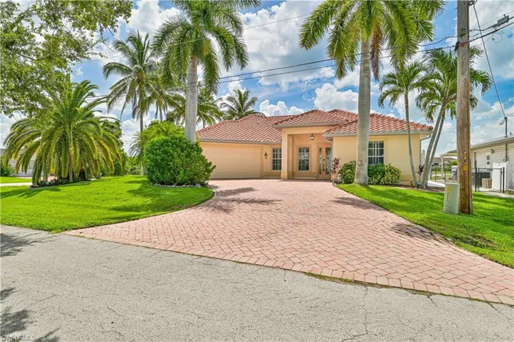 Mediterranean / spanish house with a garage and a front lawn