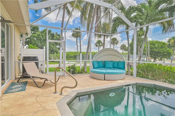 View of swimming pool featuring glass enclosure and a patio area