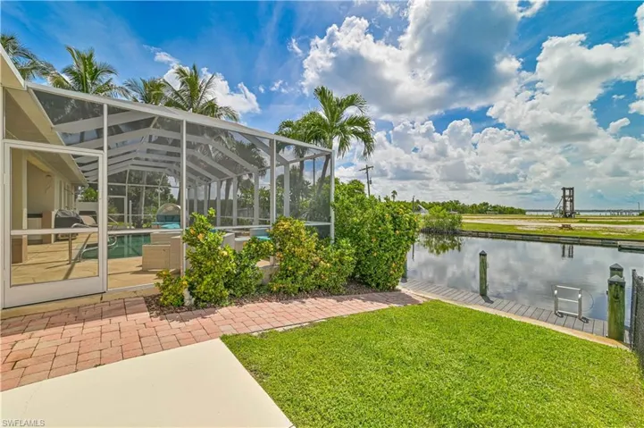 View of yard featuring a water view, a patio, and a lanai