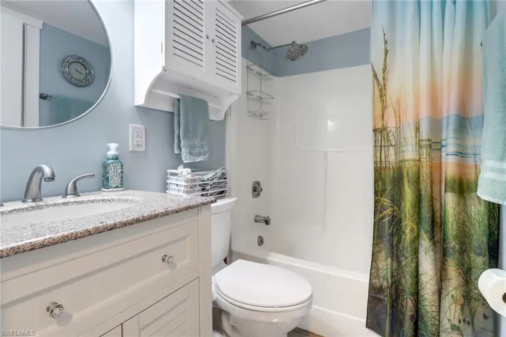Full bathroom featuring vanity, shower / tub combo with curtain, and toilet