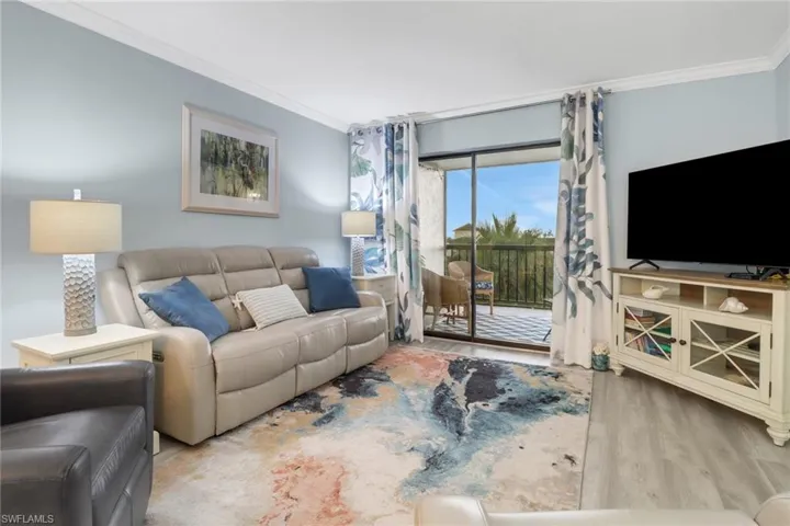 Living room featuring crown molding and light hardwood / wood-style floors