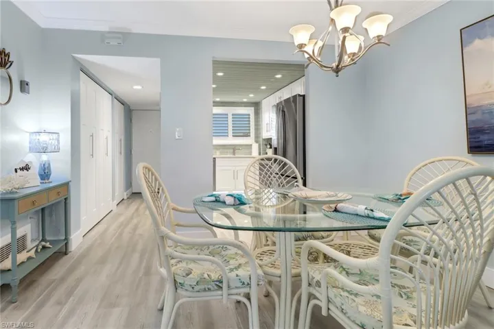 Dining area with an inviting chandelier, crown molding, and light hardwood / wood-style flooring