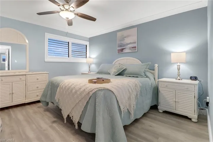 Bedroom with crown molding, light hardwood / wood-style flooring, and ceiling fan