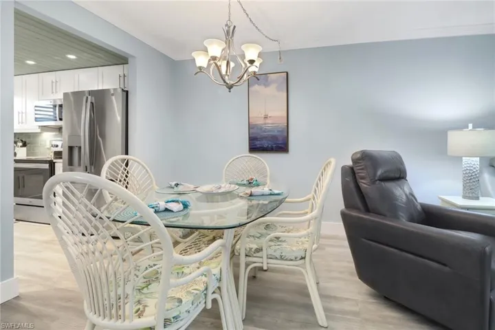 Dining space with an inviting chandelier, light wood-type flooring, and ornamental molding
