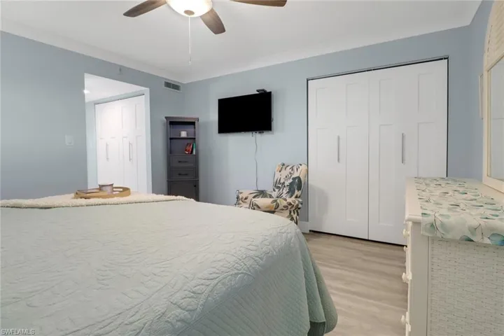 Bedroom with ceiling fan, crown molding, and light hardwood / wood-style flooring