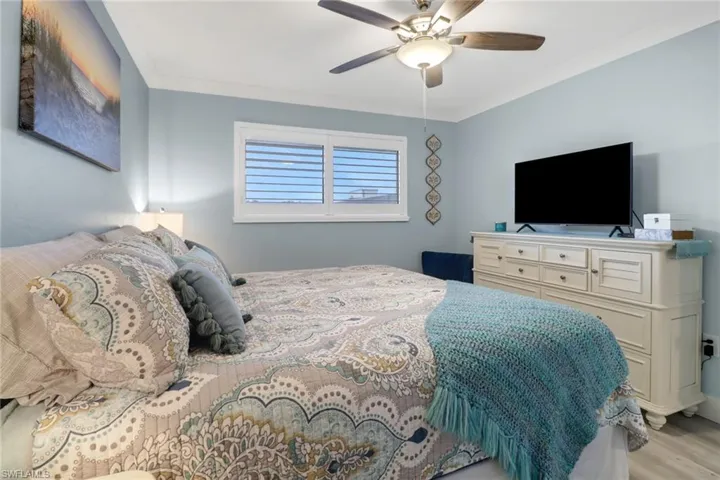 Bedroom with crown molding, light hardwood / wood-style flooring, and ceiling fan