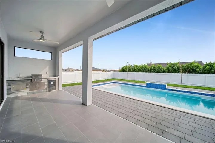View of swimming pool featuring area for grilling, a patio, ceiling fan, and a grill