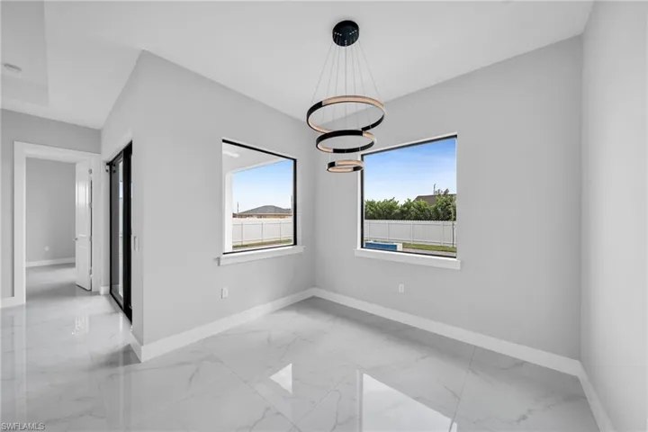 Unfurnished room featuring light tile patterned flooring and a chandelier