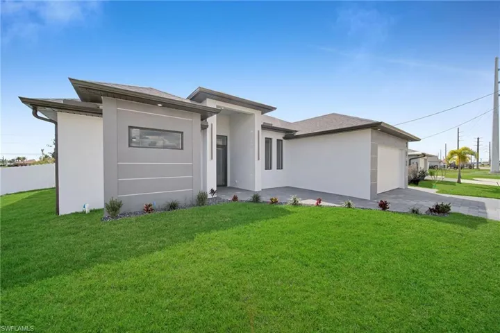 View of front of house with a garage and a front yard