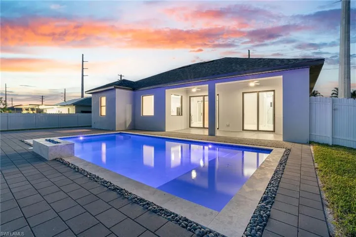 Pool at dusk featuring a patio area