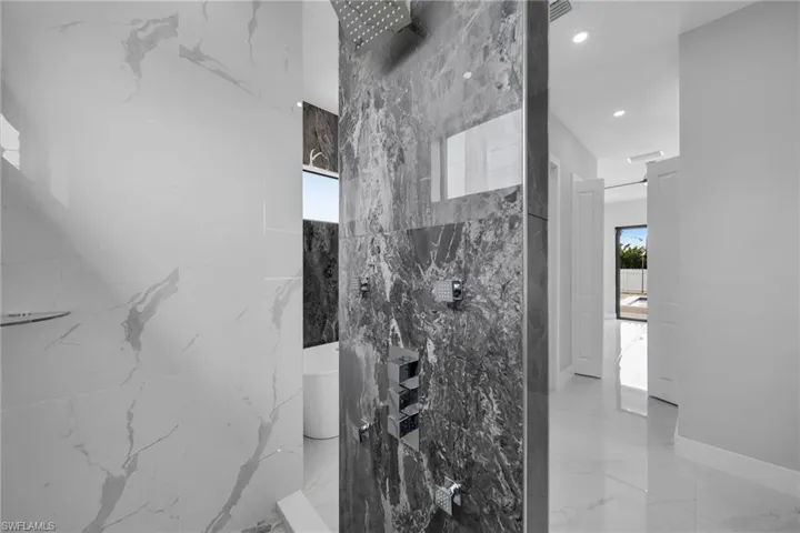 Bathroom with tile patterned flooring and a tile shower