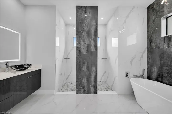 Bathroom with vanity, shower with separate bathtub, tile patterned flooring, and tile walls