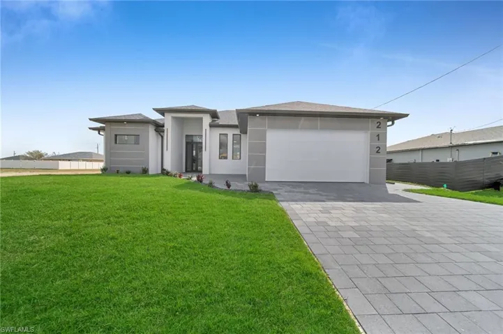 View of front of property featuring a garage and a front yard