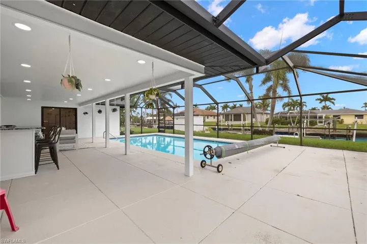 View of swimming pool featuring a lanai and a patio