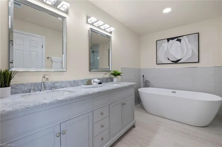 Bathroom featuring tile walls, tile patterned floors, and double sink vanity