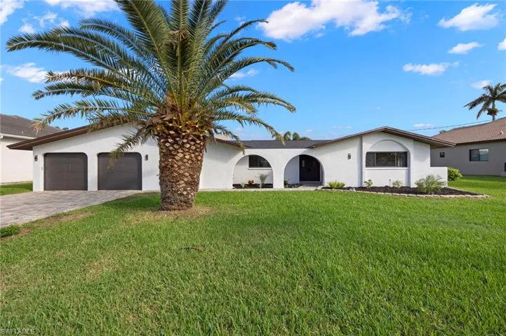 View of front of house with a garage and a front lawn