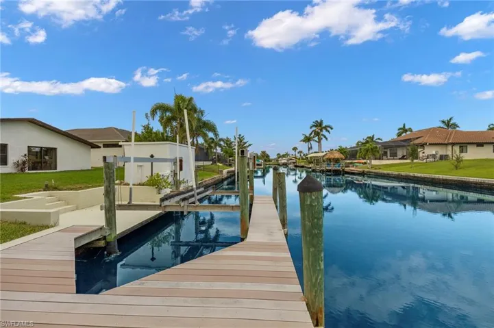View of dock with a water view and a yard