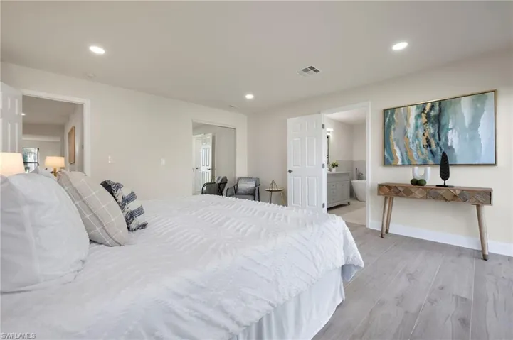 Bedroom featuring ensuite bath and light hardwood / wood-style flooring