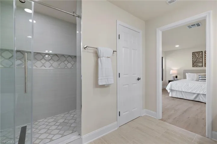 Primary Bathroom featuring walk in shower and tile patterned floors