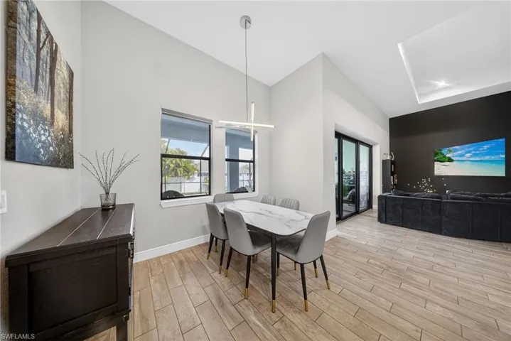 Dining area featuring wood finish floors, vaulted ceiling, and healthy amount of natural light