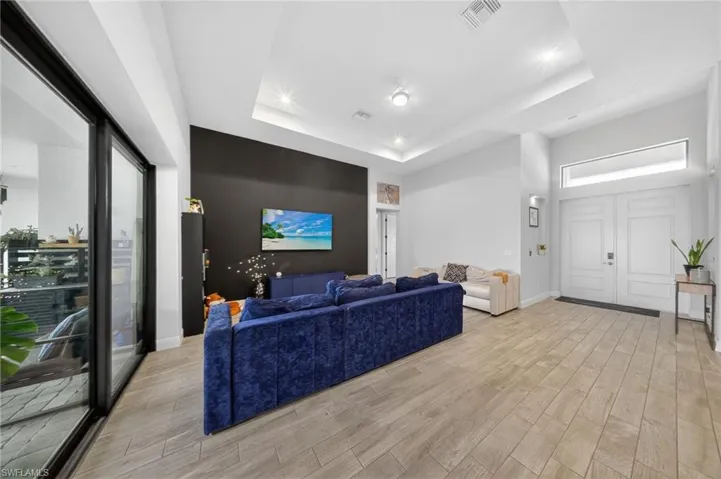 Living area with light wood-style floors and a raised ceiling