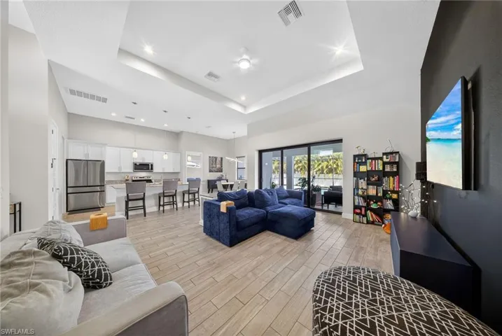 Living room featuring wood finish floors, recessed lighting, and a raised ceiling