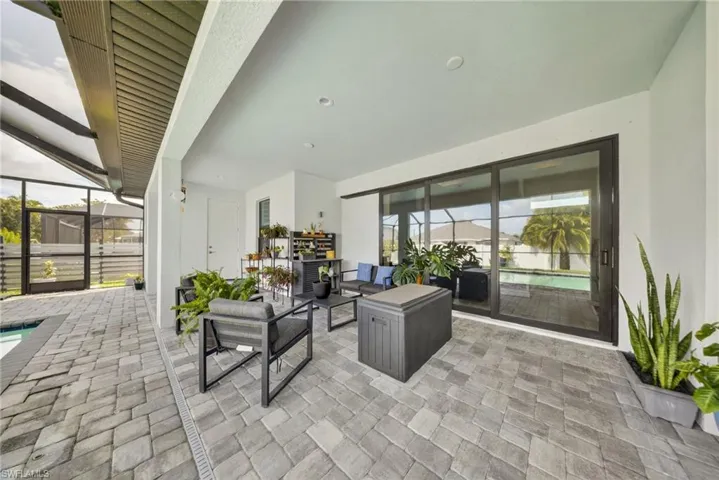 View of patio featuring glass enclosure, a sunroom, an outdoor hangout area, and an outdoor pool
