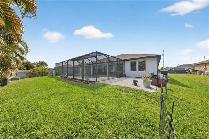 Rear view of house with a sunroom, a lanai, a patio area, and stucco siding