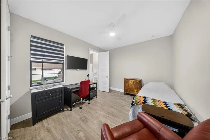 Office with light wood-type flooring and a ceiling fan