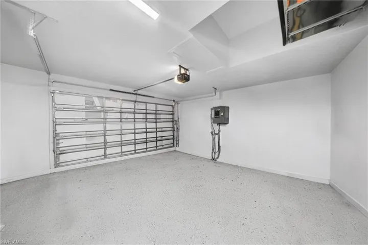 Garage featuring baseboards and electric panel