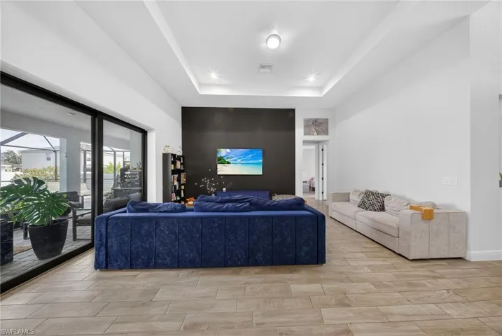 Living room featuring a tray ceiling and wood finish floors